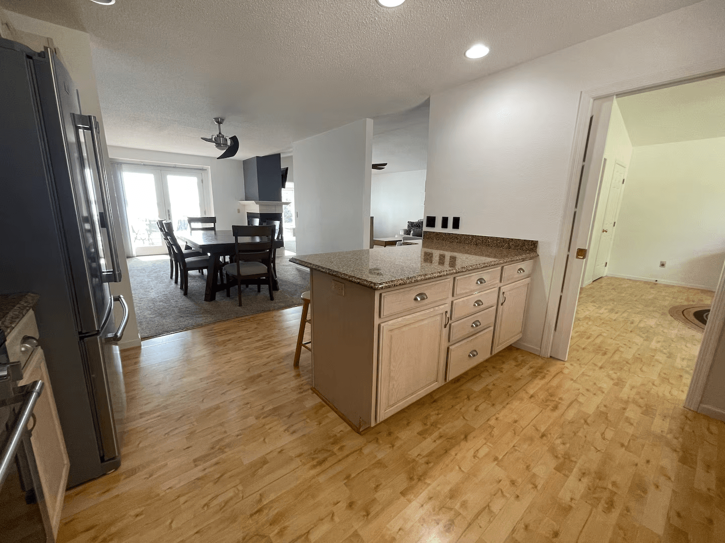 Open concept kitchen and dining area with island & barstools between.