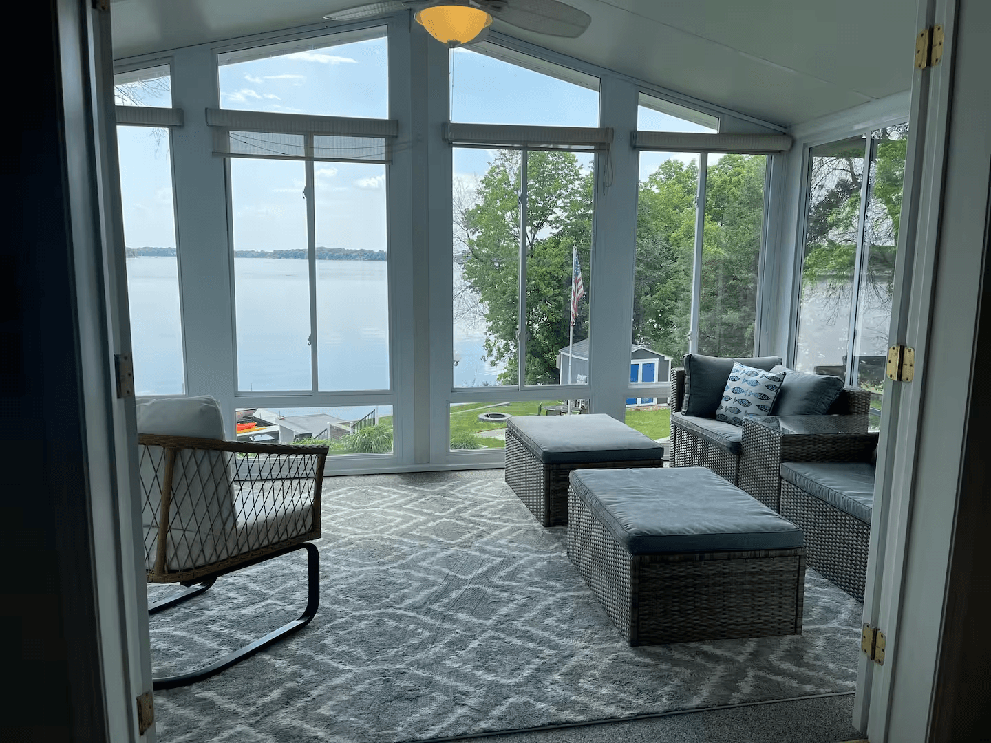 Four-season room with comfortable seating and expansive lake views.
